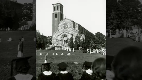 Students in caps and gowns on the yard in front of the Chapel.