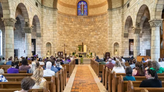A view of the altar from the back of the Chapel shows the pews on either side of the aisle filled with people.