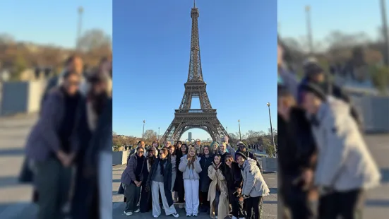 A group of St. Kate's students pose in front of the Eiffel Tower