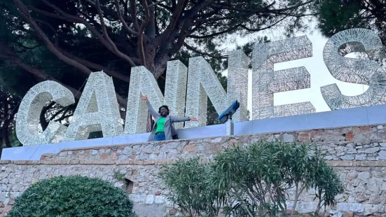 Maria Ngangsic-Asongu ’25 sits on a wall, under a large sign reading "Cannes"