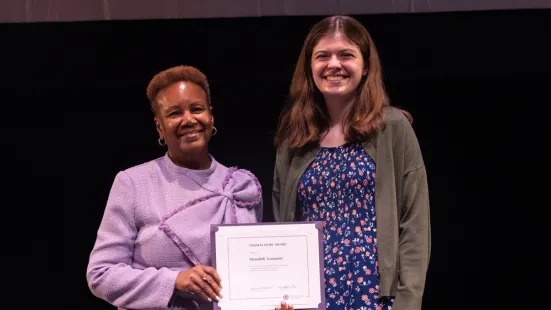 President Evans stands next to a student and holds a certificate. 