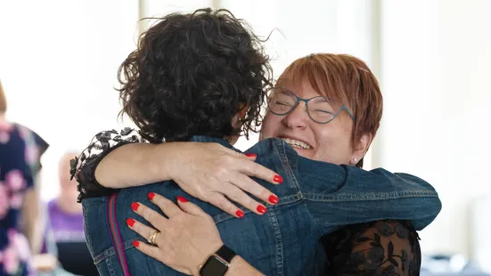 Two people, one with their back to the camera, embrace in a hug.