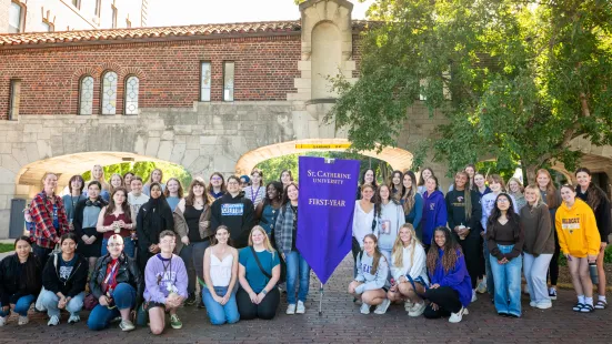 A group of students pose with a purple banner that reads "First-Year"