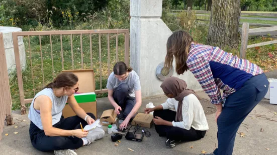 Paula Furey, PhD, observing three students as they measure water samples.