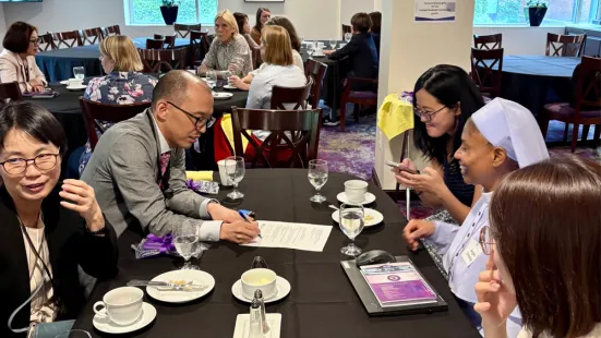 Visitors from Kansai Medical University sit and talk with St. Kate's faculty at a table.