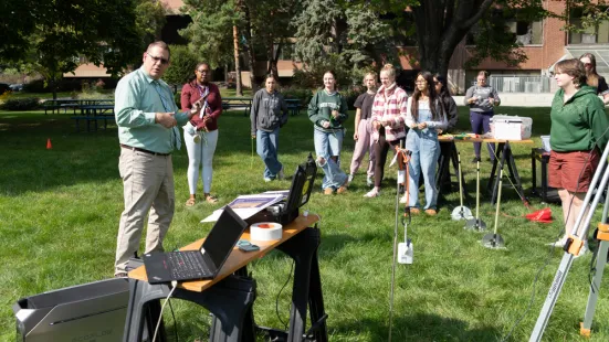 Erick Agrimson (left) with various students and weather equipment.