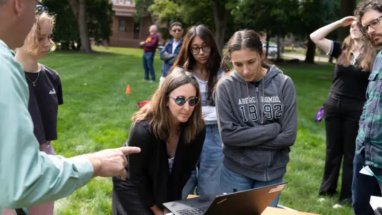 Paula Furey, PhD, (center) with two students watching a computer monitor.