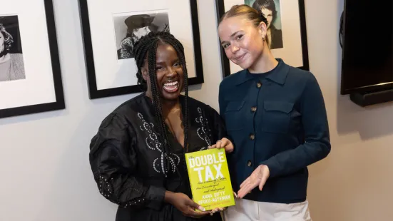 Opoku-Agyeman and Walz smile and pose with The Double Tax book.