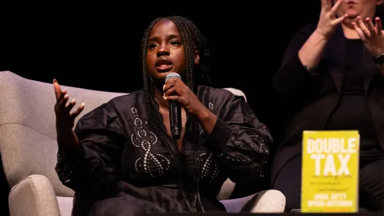 Opoku-Agyeman speaks into a microphone on stage.