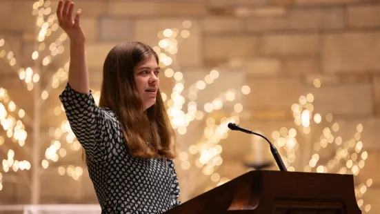 A cantor sings at a lectern in the Chapel. 