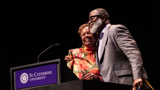 On stage, Duchesne Drew hugs President Evans.
