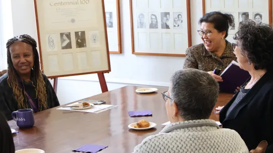 President Evans and Mayor Her smile in discussion at a table with several others.