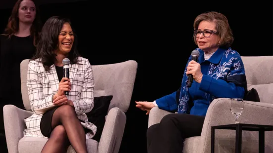 Brandi Powell and Valerie Jarrett sit in armchairs on a stage during the moderated conversation.