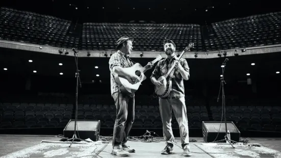 Two men playing a guitar and banjo on stage