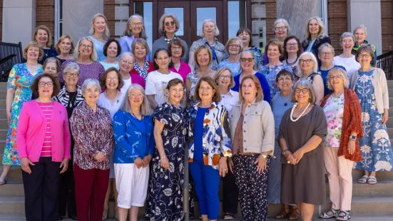 A group of alumni pose on the front steps of Derham during Reunion.