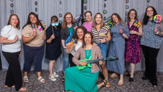 A group of alumni pose with props at a photo station during Reunion.