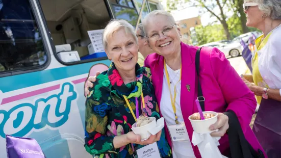 Two alums smile in front of the ice cream truck at Reunion.