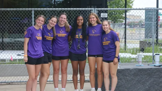 Wildcat soccer players wearing purple T-shirts pose together at the MN United STEM clinic.