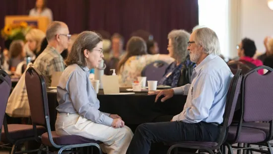 People sit talking at a table during the retreat.