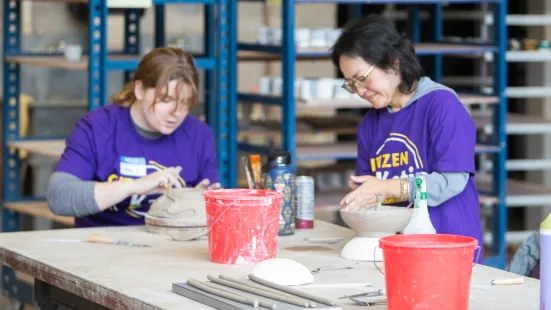 Volunteers build bowls out of clay. 