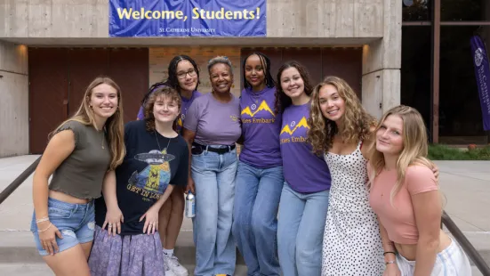 President Evans poses with a group of students in front of a banner that reads "Welcome, Students!"