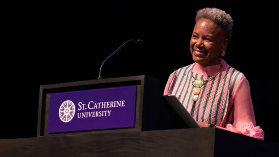President Evans stands behind a podium on stage at The O'Shaughnessy.