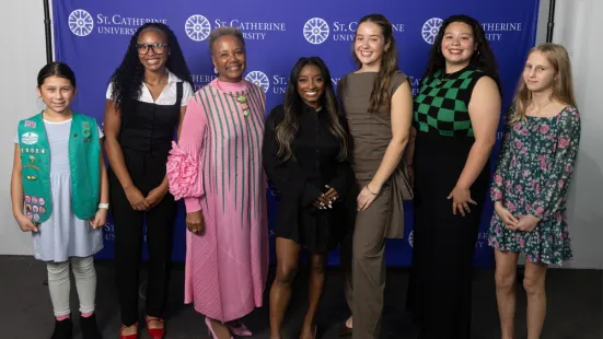 Simone Biles and President Evans stand with five student-athletes.