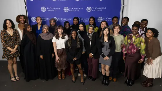 A group of young alumni pose with Simone Biles. 