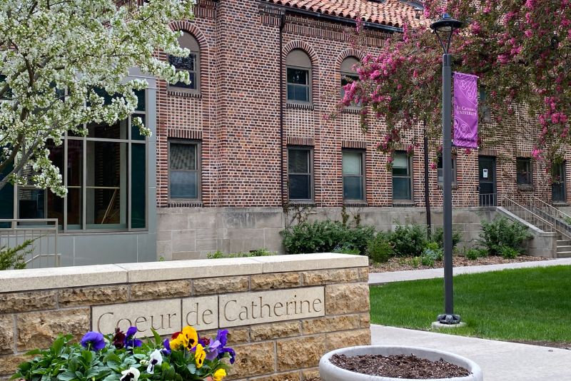 St. Catherine University Coeur de Catherine building on St. Paul, MN campus in spring; brick building with flowers blooming