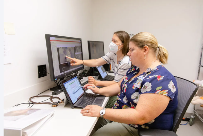two nursing educators looking at a computer display of patient results