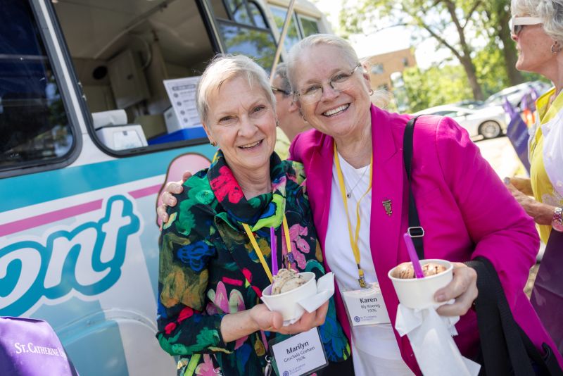 Two alums smile together in front of the ice cream truck at Reunion.