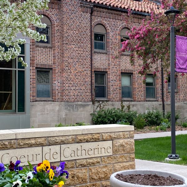 St. Catherine University Coeur de Catherine building on St. Paul, MN campus in spring; brick building with flowers blooming