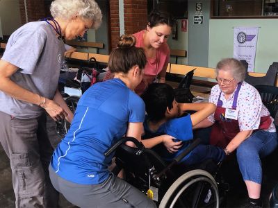 Occupational therapists assisting child with wheelchair
