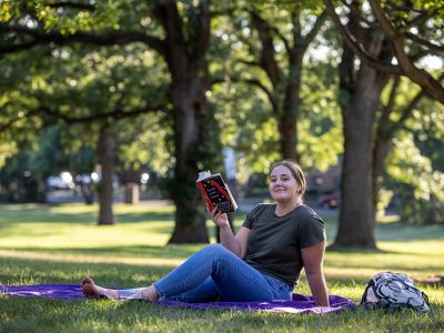 Student reading a book on campus