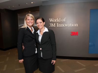Two business women posing for picture at a conference