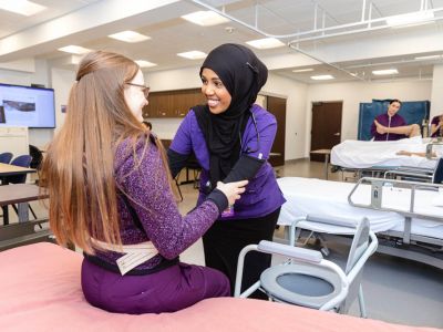 Nursing student helping patient in a hospital simulation