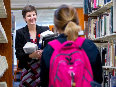 Woman helping a student in the Library