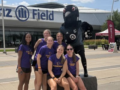 Wildcat soccer team members pose outside Allianz Field with the loon mascot
