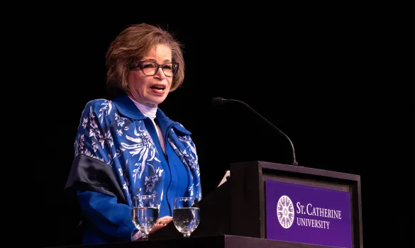 Valerie Jarrett speaks at a podium in The O'Shaughnessy.