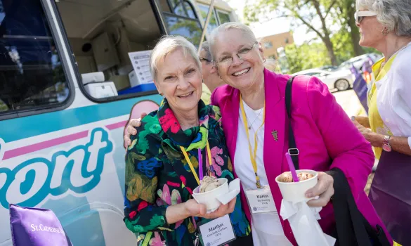 Two alums smile together in front of the ice cream truck at Reunion.