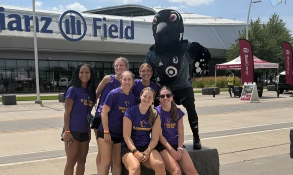 Wildcat soccer team members pose outside Allianz Field with the loon mascot