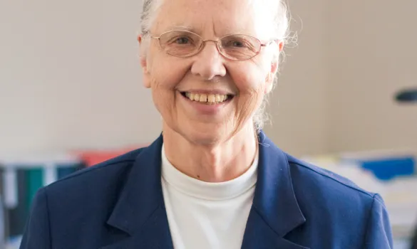 Sister Amata Miller smiling in a blue blazer, with her hair pulled back.