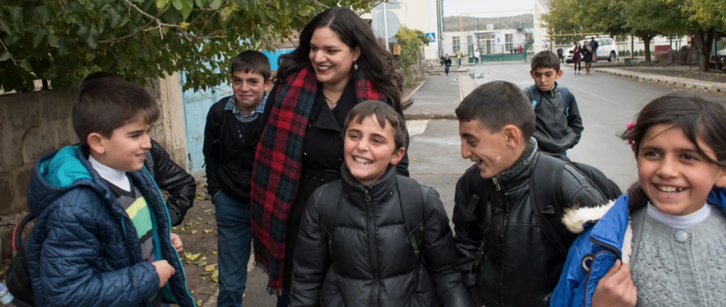 Woman and a bunch of kids walking down street
