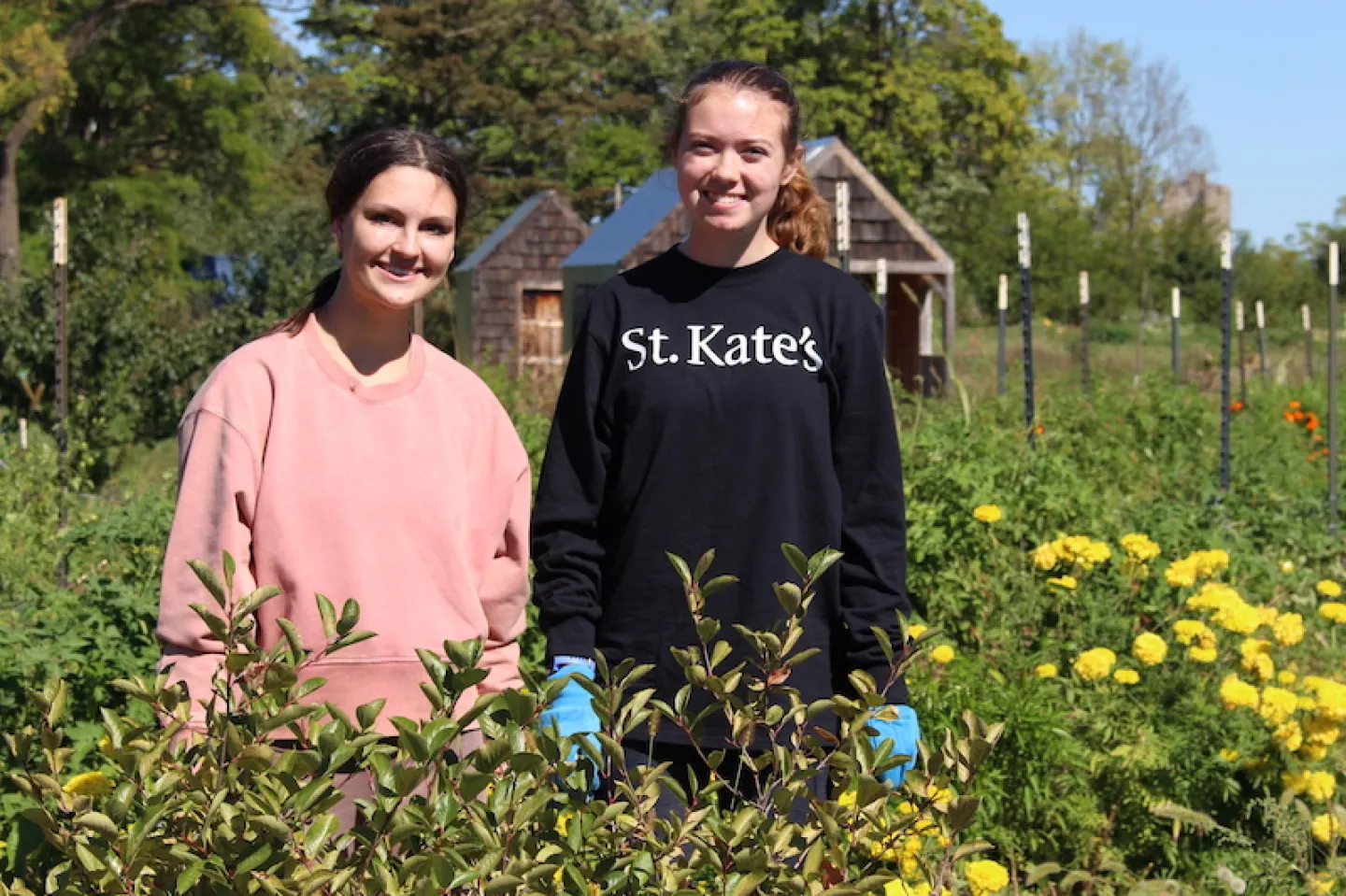 Two women stand in a community garden