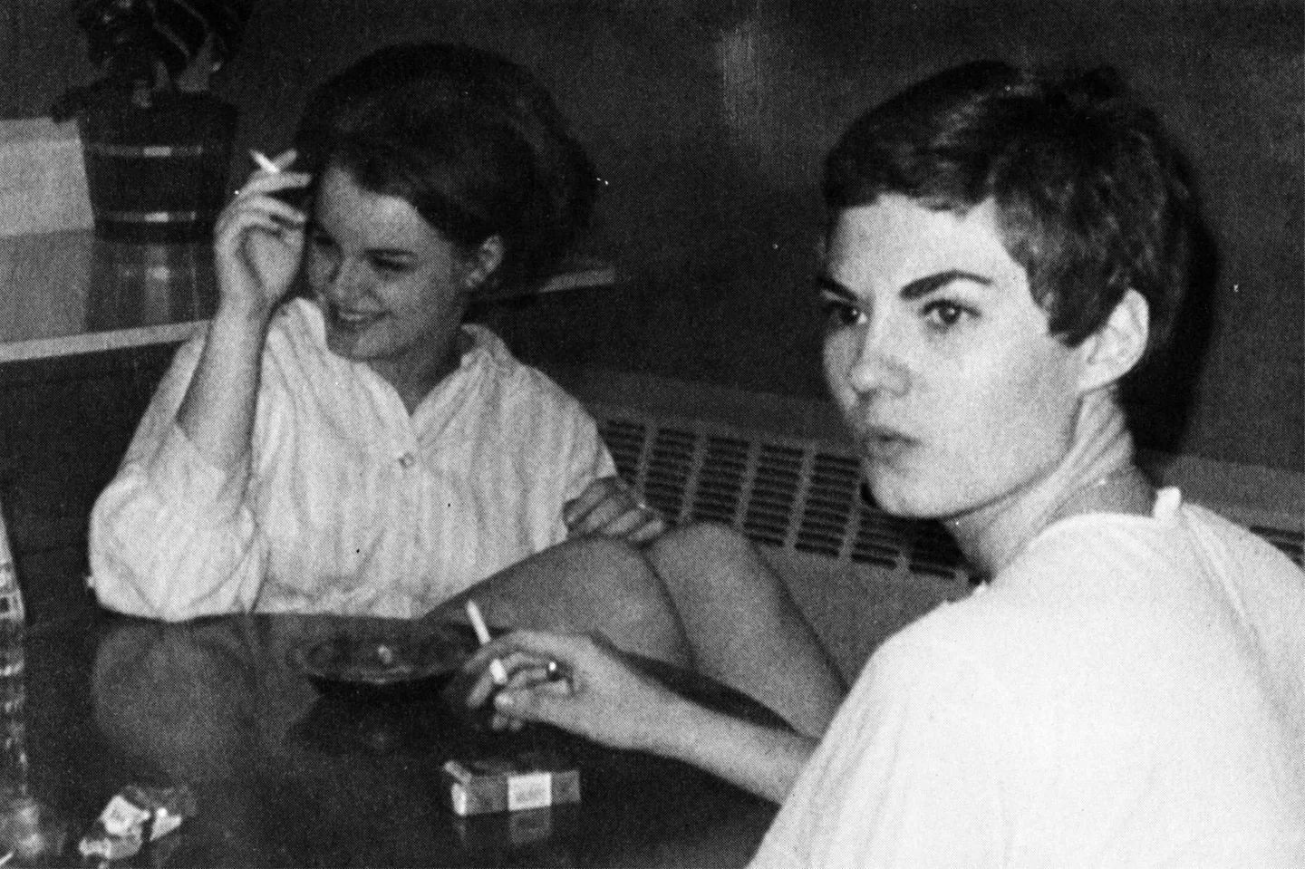 Black and white photo of two students smoking