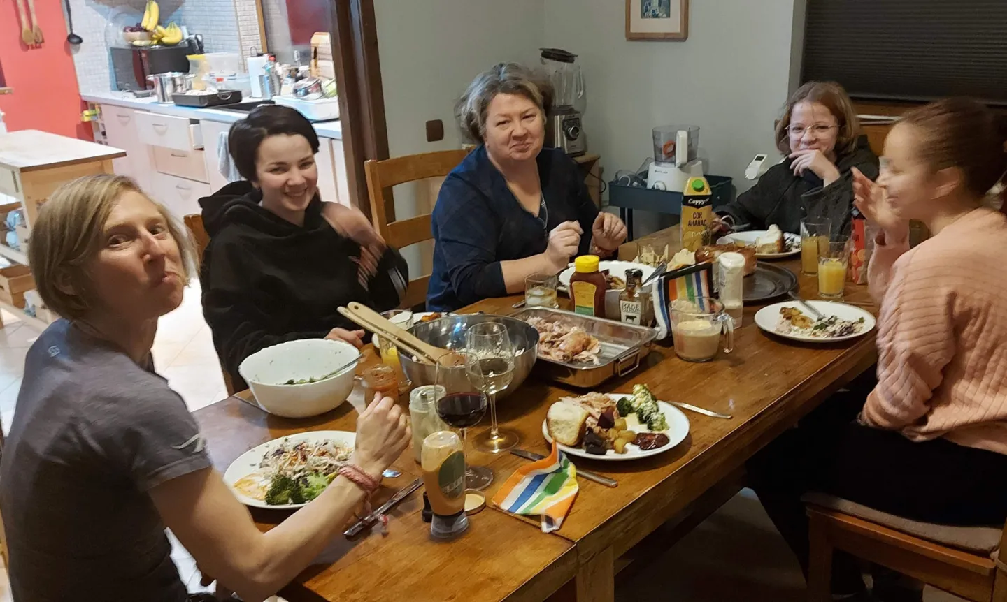 Five women of different ages eat around a table