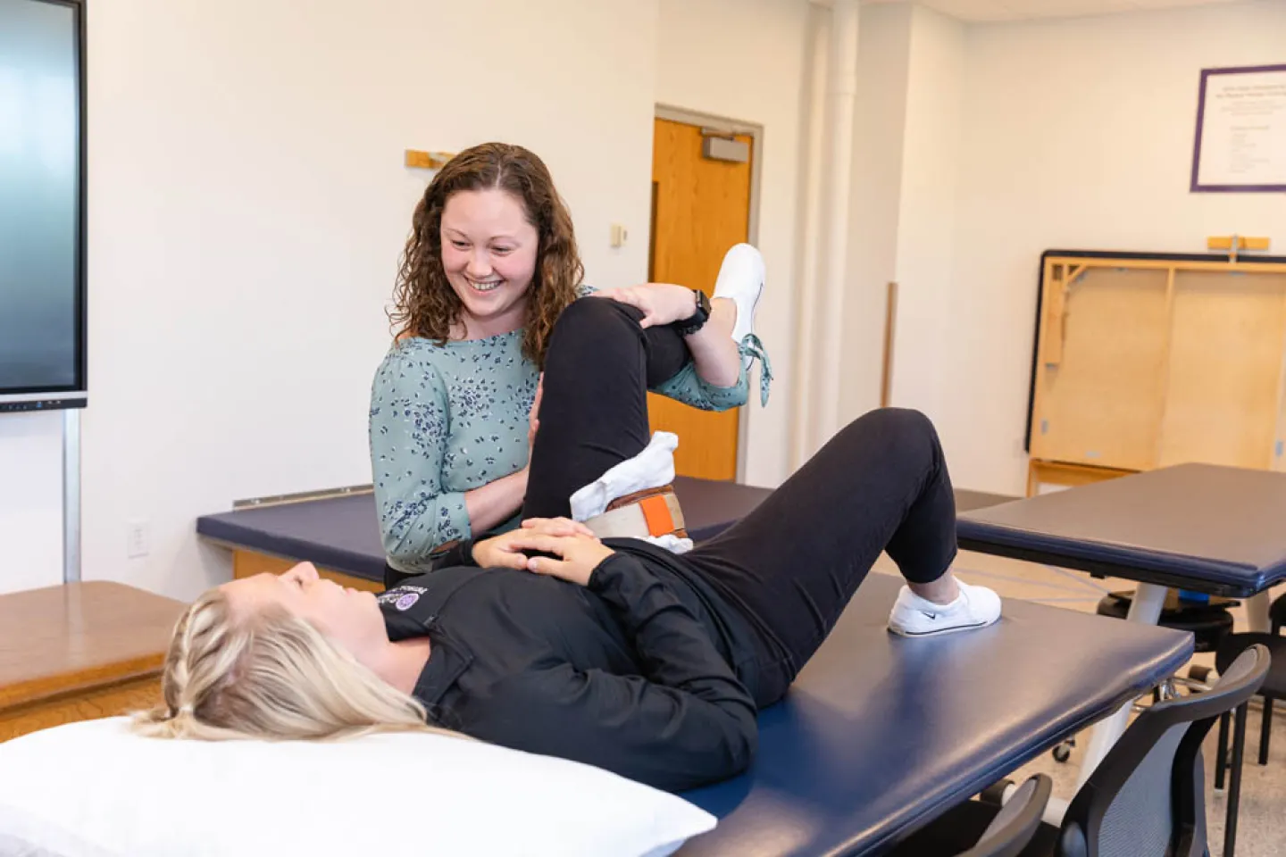 Physical therapist helping a patient with leg exercises