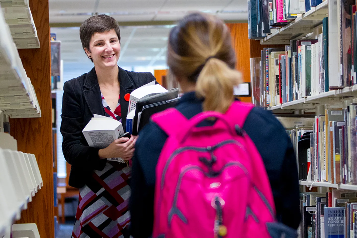 Woman helping a student in the Library