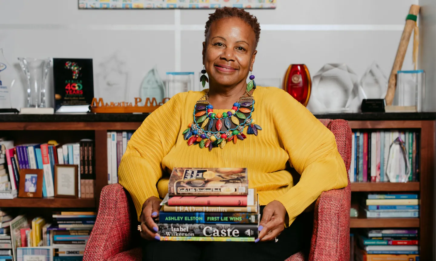 President Evans holding a stack of books.