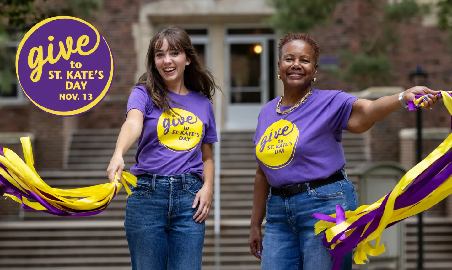 Two people wearing purple T-shirts and jeans wave ribbons. In the corner is a purple "Give to St. Kate's Day" logo.